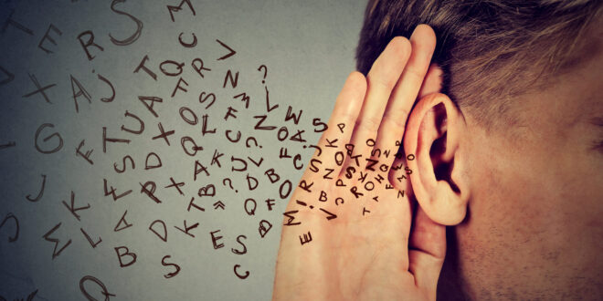 man holds hand near ear listens carefully alphabet letters flying in