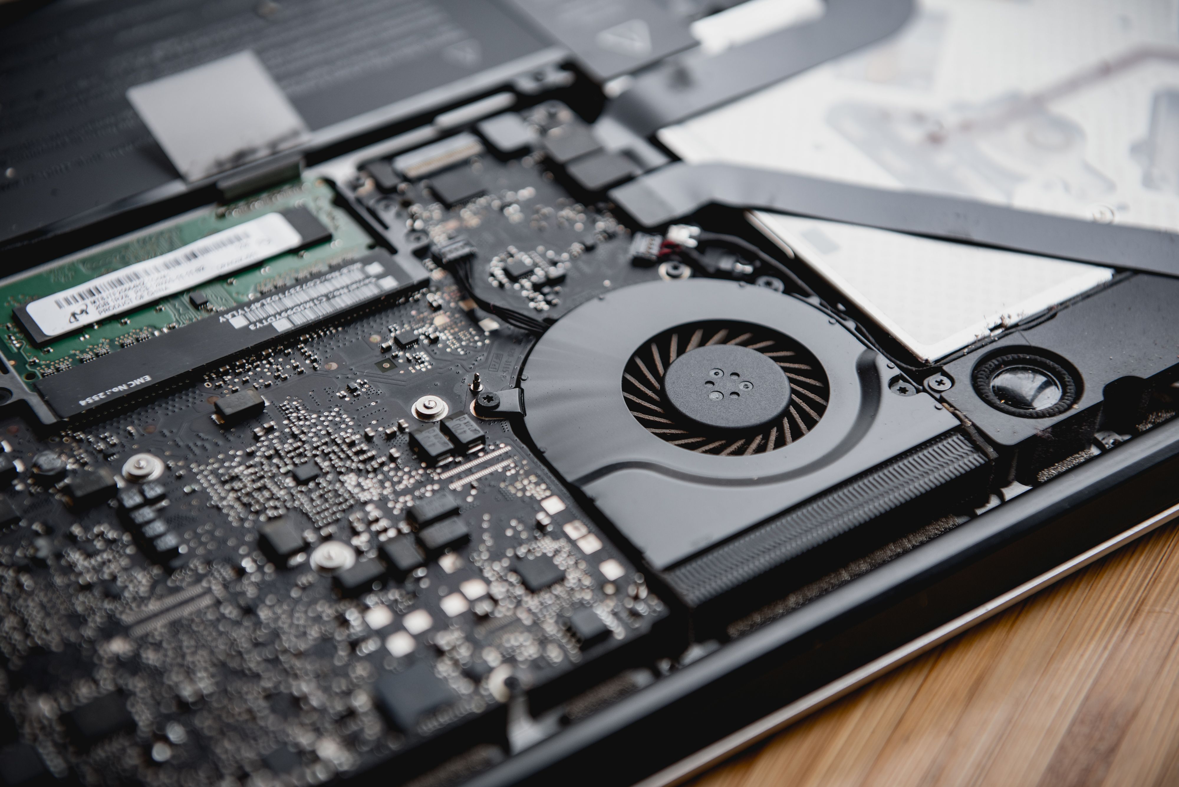 Laptop cooling fan and internal circuitry, illustrating heat and cooling issues that can affect performance.