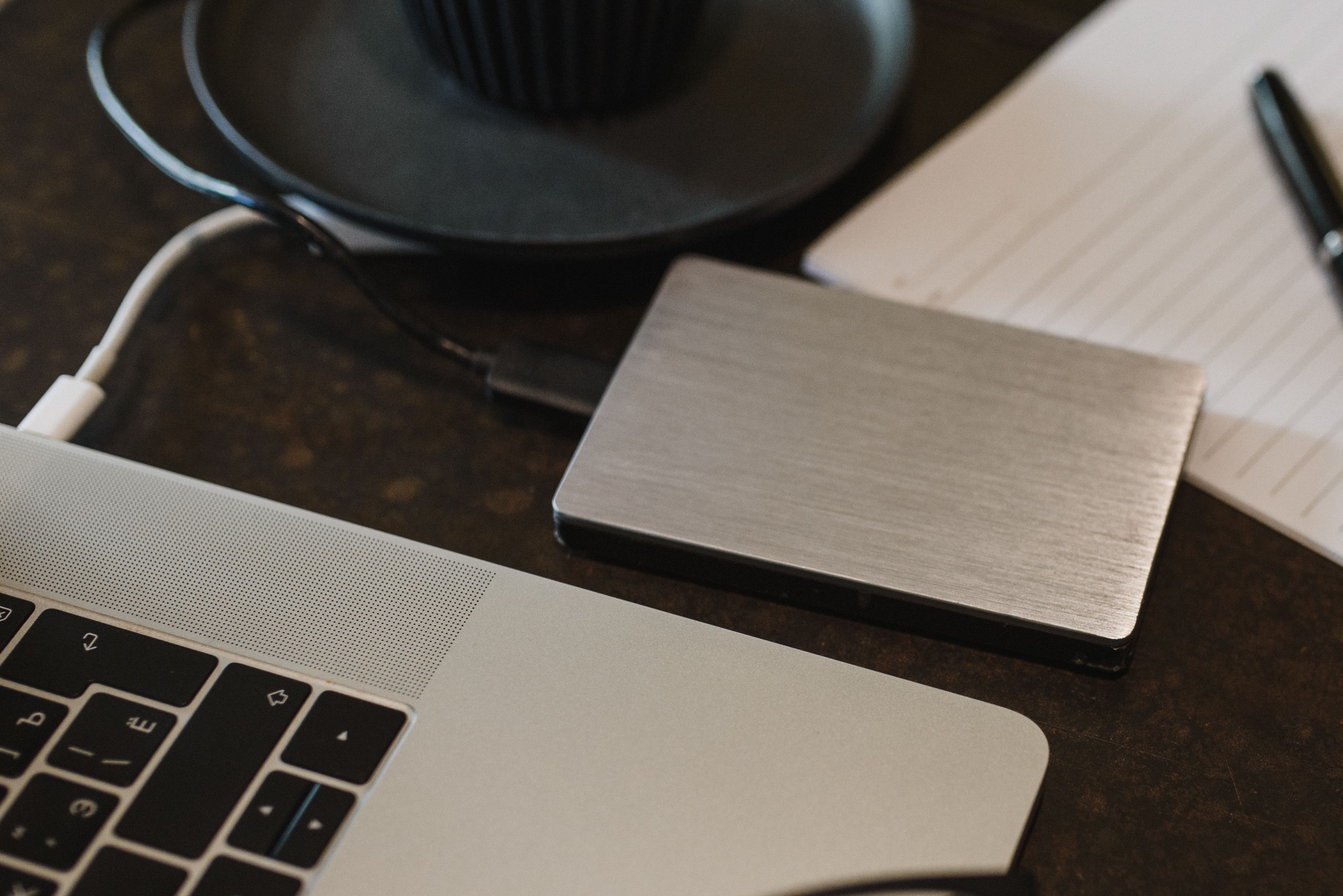 External hard drive connected to a laptop, representing storage pressure and file cleanup as possible causes of slow performance.