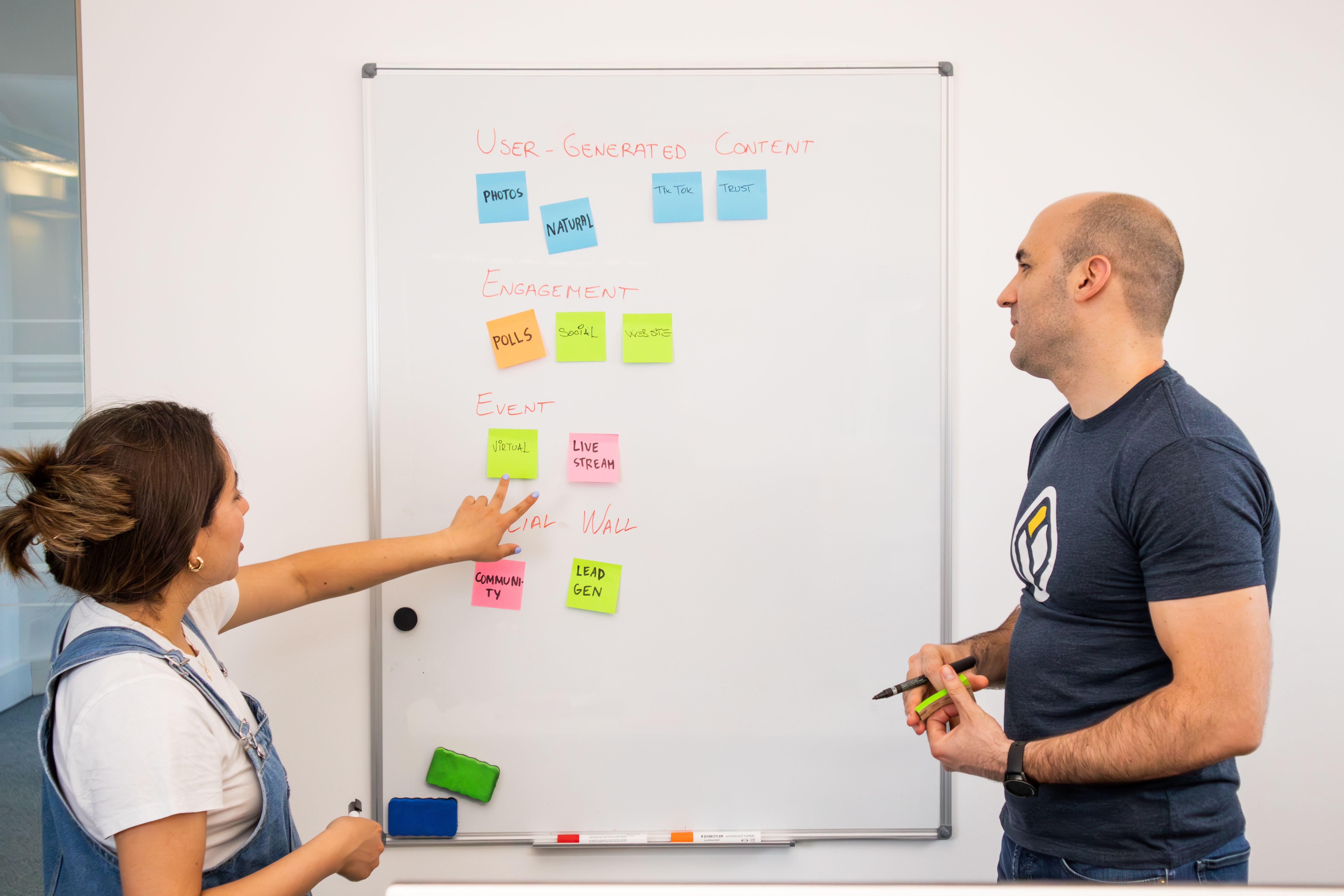 Two colleagues planning together at a whiteboard, illustrating a quieter, small-group team activity.