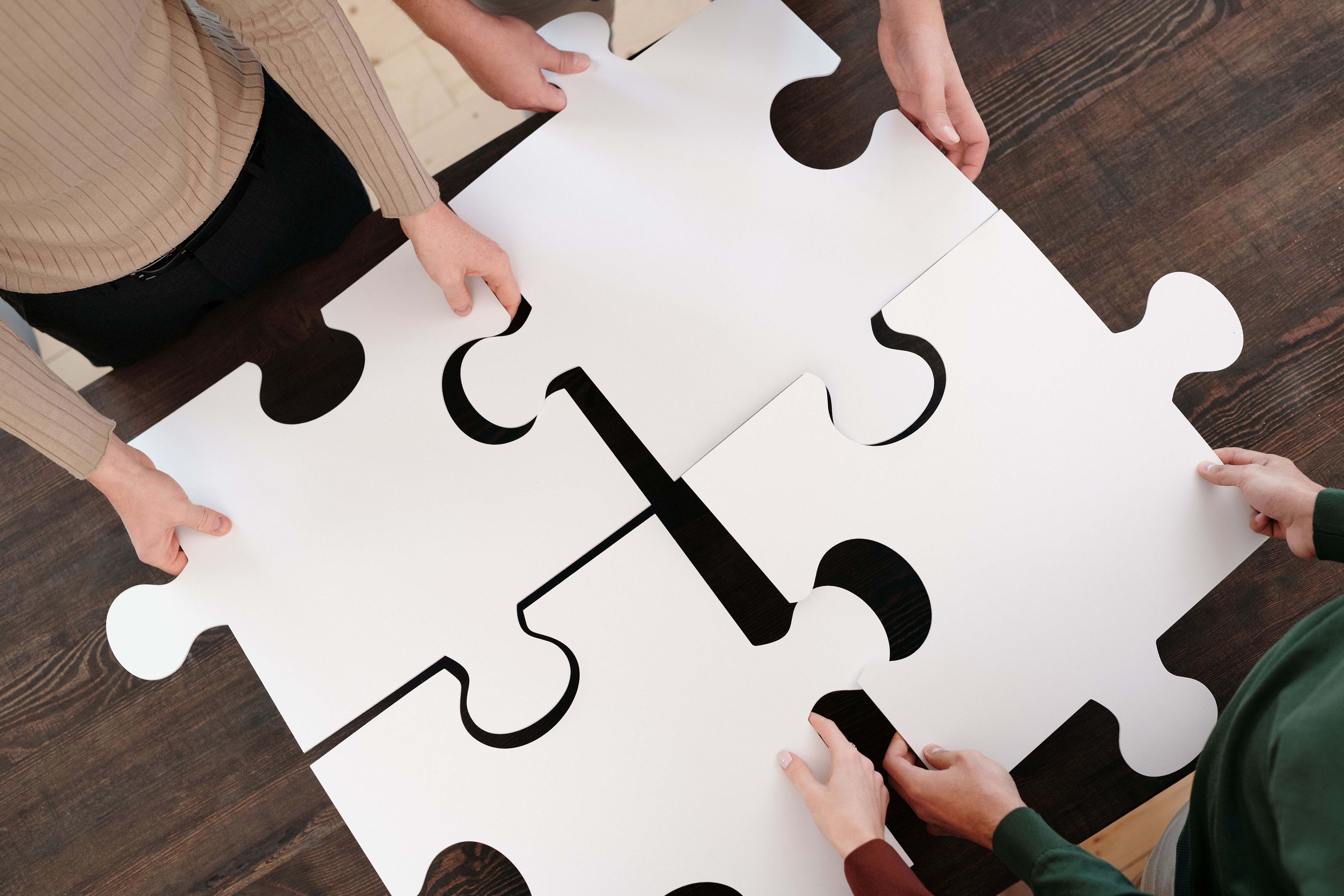 Teammates work together to assemble oversized puzzle pieces in a hands-on problem-solving activity.